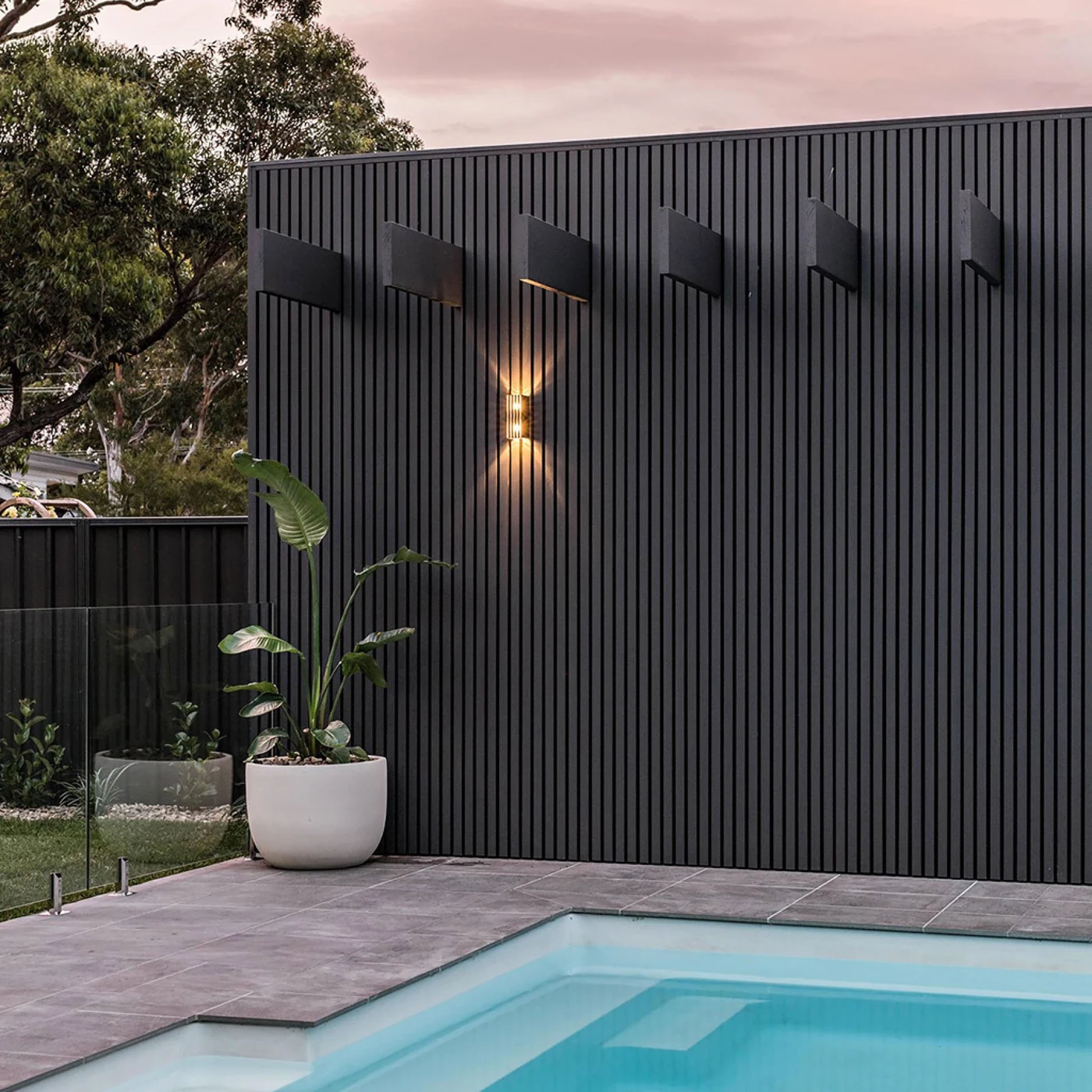 Dark fluted exterior cladding by a swimming pool